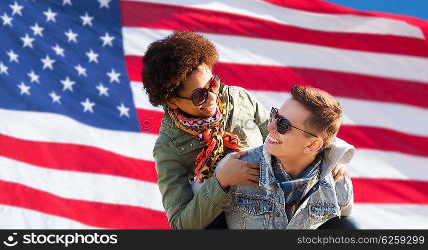 international friendship, freedom and people concept - happy teenage couple in shades having fun over american flag background