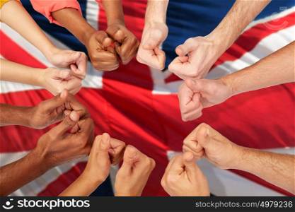 international, immigration, patriotism, ethnicity and people concept - hands showing thumbs up over british flag background. hands of international people showing thumbs up