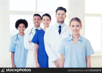 international, profession, people and medicine concept - group of happy doctors and nurses at hospital. group of doctors and nurses at hospital