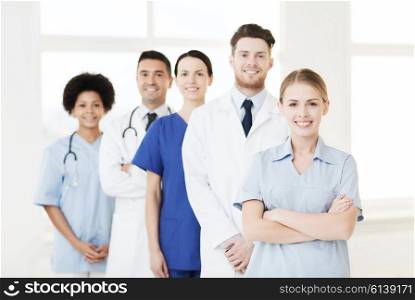 international, profession, people and medicine concept - group of happy doctors and nurses at hospital