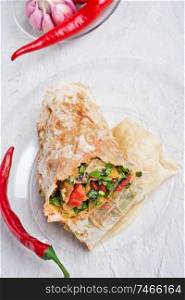 international vegetarian  shawarma sandwich roll with chili and spices. served at white table. arabian and caucaisian cuisine. Healthy fast food. close up