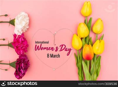 International Woman's Day with flowers and heart shape necklace on pink background