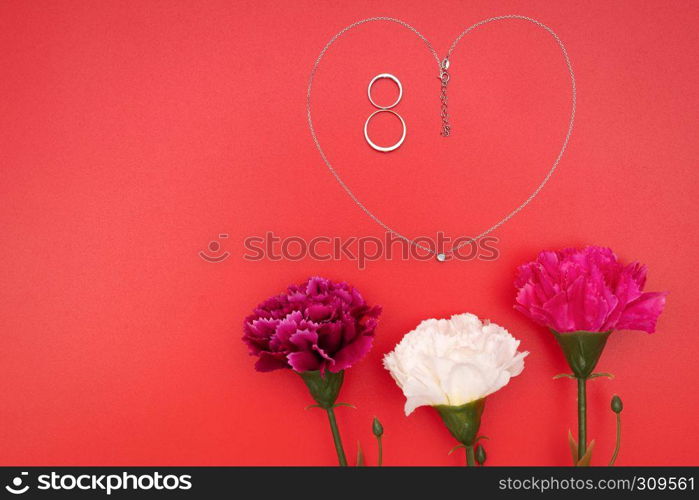 International Woman's Day with flowers and heart shape necklace on red background