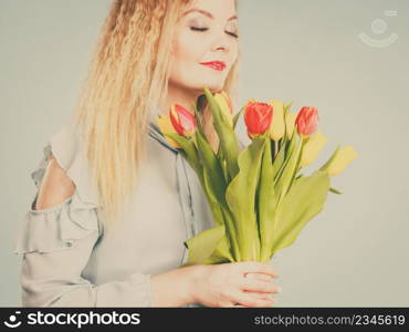 International women day, eight march. Beautiful portrait of pretty woman blonde hair with red yellow tulips, fashion make up. Mother day. Toned image. Pretty woman with red yellow tulips bunch