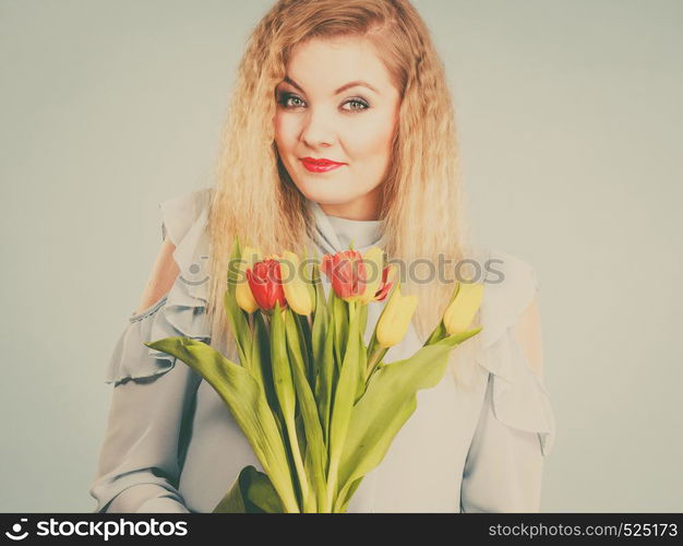 International women day, eight march. Beautiful portrait of pretty woman blonde hair with red yellow tulips, fashion make up. Mother day. Toned image. Pretty woman with red yellow tulips bunch