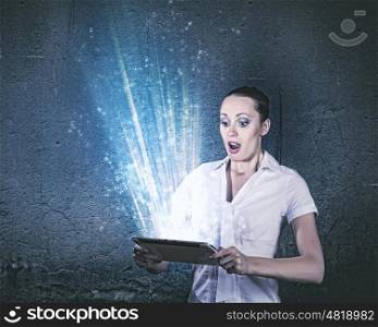 Internet addiction. Young businesswoman looking astonished into tablet pc