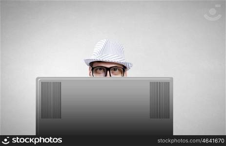 Internet addiction. Young man looking out above laptop monitor