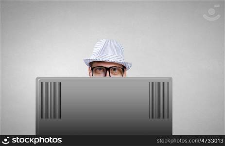 Internet addiction. Young man looking out above laptop monitor