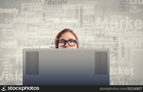 Internet addiction. Young woman looking out above laptop monitor