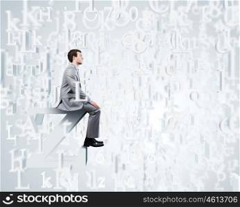 Internet communication. Young businessman sitting on huge white letter. Email concept