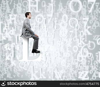 Internet communication. Young businessman sitting on huge white letter. Email concept