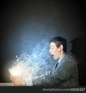 Internet communication. Young man sitting at table and using laptop