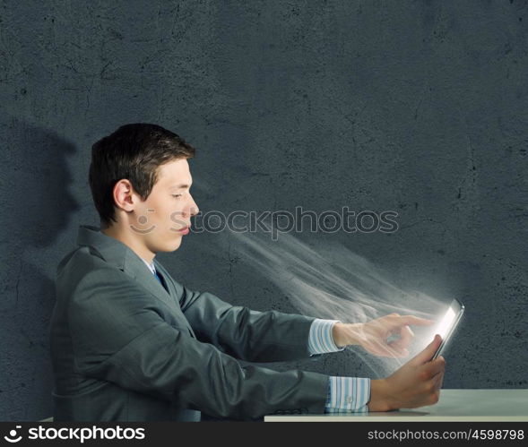 Internet communication. Young man sitting at table and using laptop