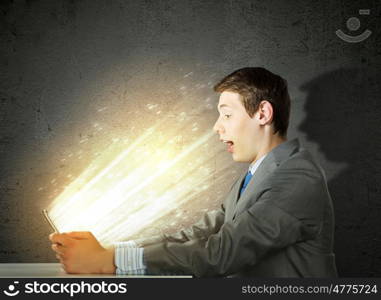 Internet communication. Young man sitting at table and using laptop