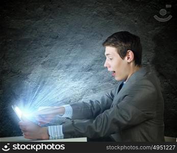 Internet communication. Young man sitting at table and using laptop