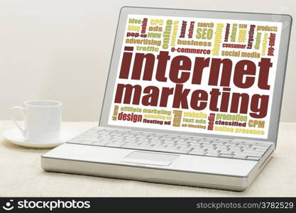 internet marketing - word cloud on a laptop with a cup of coffee