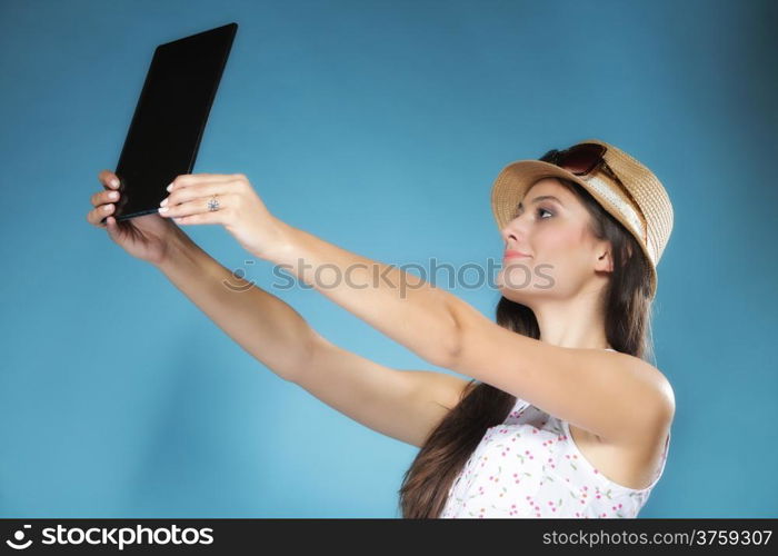 Internet modern lifestyle concept. Young summer girl in hat using tablet computer reading. Latin female with e-book reader touchpad pc.