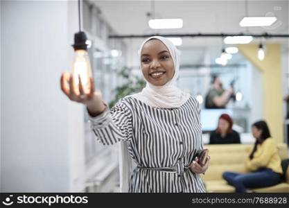 internet of things concept woman holding hands around bulb smart saving energy wearing hijab as traditional muslim