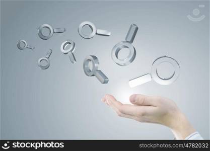 Internet search icon. Businessman hand holding search glass icons in palm