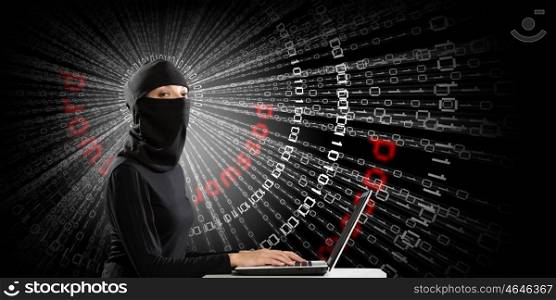 Internet security concept. Hacker woman in dark clothes using laptop against digital background