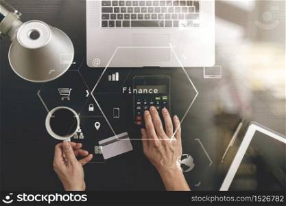 Internet shopping concept.Top view of hands working with calculator and laptop and credit card and tablet computer on dark wooden table background with Vr diagram