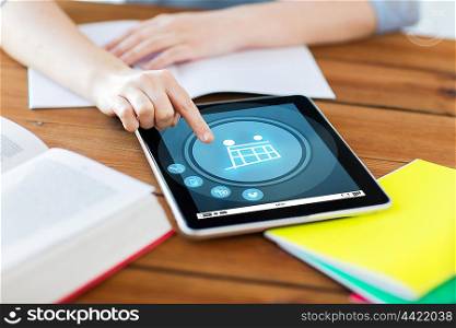 internet, technology and internet concept - close up of student woman with shopping cart on tablet pc computer and notebook at home