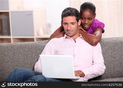 Interracial couple looking at their laptop