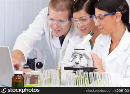 Interracial Team of Scientists In Laboratory With Laptop