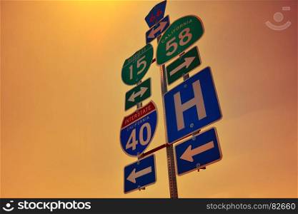 Interstate 40 road signs with dawn lights on San Bernardino county, California.