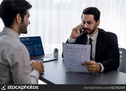 Interviewing job applicant in office with resume paper. Candidate wear suit for formal conversation with interviewer. Recruitment process with question about career and work experience. Fervent. Interviewing job applicant in office with resume paper. Fervent