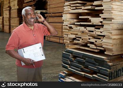 Inventory Manager on Cell Phone in Lumber Warehouse