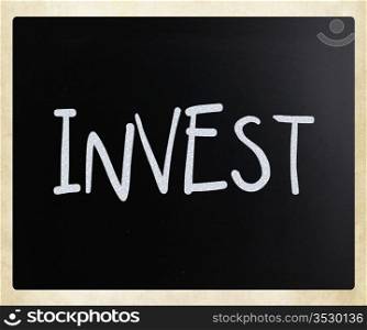 ""Invest" handwritten with white chalk on a blackboard."