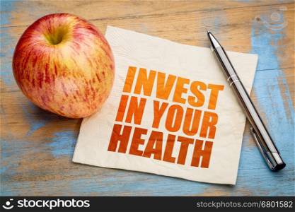 Invest in your health - inspirational word abstract on a napkin with a fresh apple