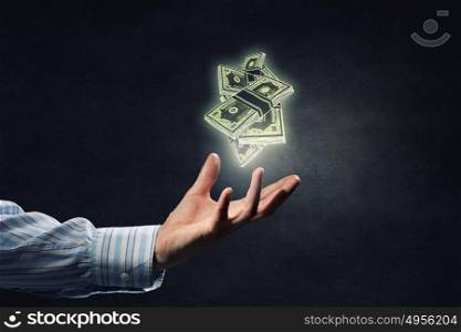Invest your money right. Businessman hand holding drawn banknotes in palm on dark background