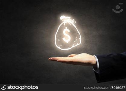 Invest your money right. Hand of businessman holding money bag symbol on dark background