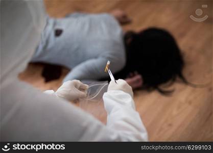investigation, forensic examination and people concept - criminalist collecting evidence of murder at crime scene. criminalist collecting crime scene evidence
