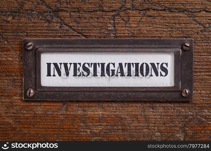 investigations - file cabinet label, bronze holder against grunge and scratched wood