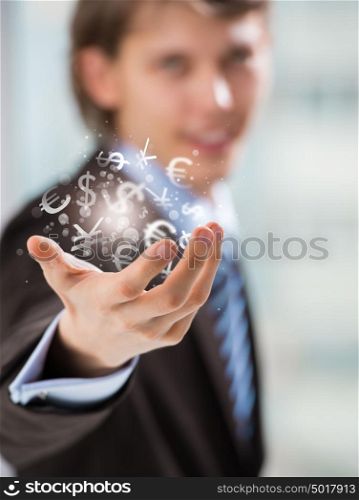 Investment concept. Handsome business man with currency symbols.