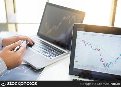 Investor analyzing financial reports of stock trading Market Graph investment charts on computer monitor screen in the office