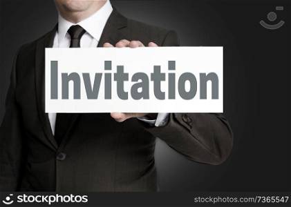 Invitation sign is held by businessman.. Invitation sign is held by businessman