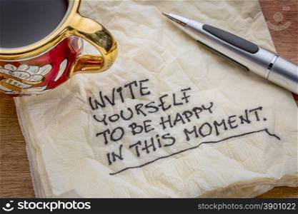 Invite yourself to be happy in this moment - inspirational advice on a napkin with a cup of coffee