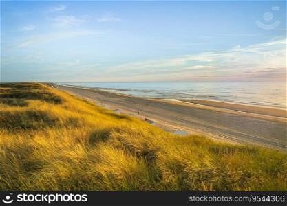 Inviting Sunset View over ocean from dune over North Sea. Outdoor scene of coast in nature of Europe.. Mesmerizing seascape during sunset in Zeeland, The Netherlands