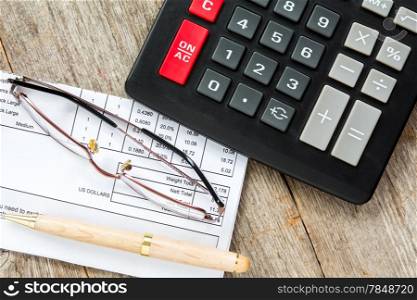Invoice with balance due, calculator,pen and glasses