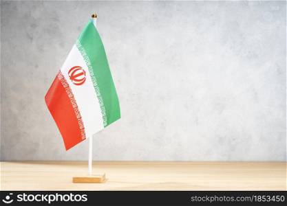 Iran table flag on white textured wall. Copy space for text, designs or drawings