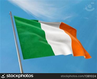 Ireland flag on a pole waving. Irish realistic flag waving against clean blue sky. Close up. Photo stock