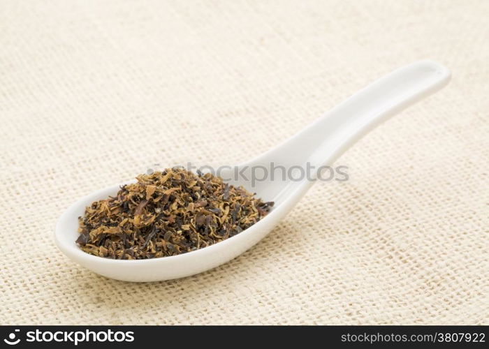 Irish moss seaweed on a white Chinese spoon against burlap canvas