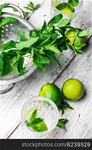 Iron bowl with the collected fresh mint and drink with lime
