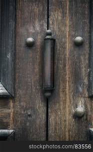 iron door hinge on old brown wooden doors, close up