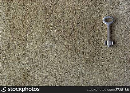 Iron key on a concrete wall
