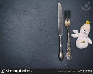 iron vintage fork and knife on a black background, empty space on the left